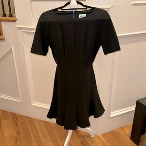 Little black dress with high collar and flattering seams flares at the bottom